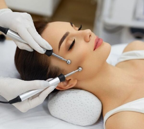 Client receiving an electrical facial with microcurrent probes