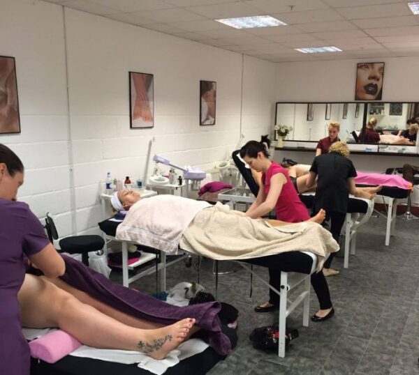 Massage students practising in a Beauty Academy training room