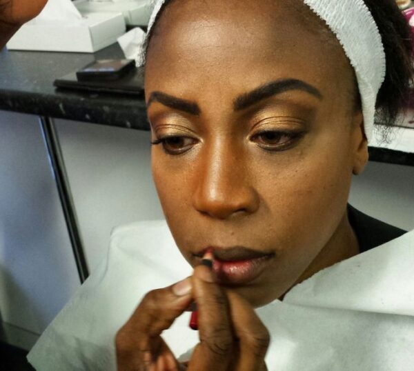 Make-up artist applying lip liner to a model