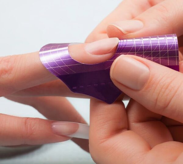 Nail form being fitted for sculpted acrylic nails