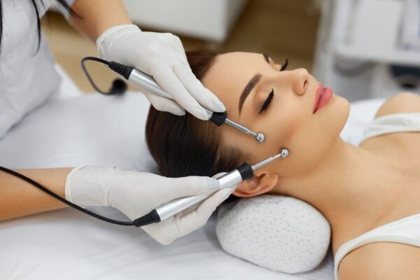 Client receiving an electrical facial with probes