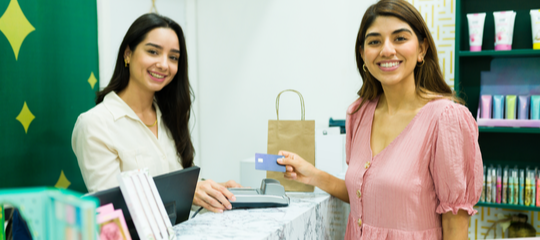 Beauty salon receptionist serving a smiling client