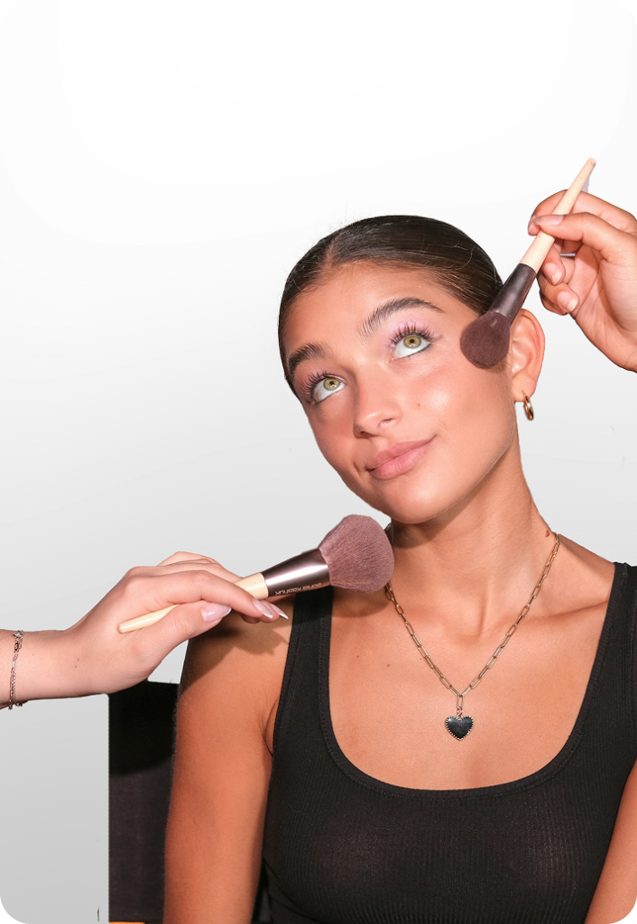 Woman having make-up applied with brushes